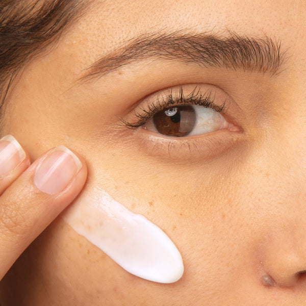 Close-up of a person applying cream to their face