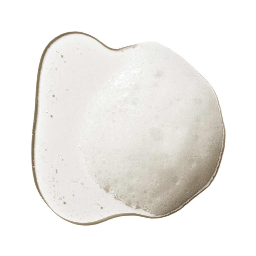 A bottle of 100% Pure Kelp & Mint Volumizing Shampoo with a white pump dispenser, containing a golden-amber liquid, set against a plain white background with a soft shadow.