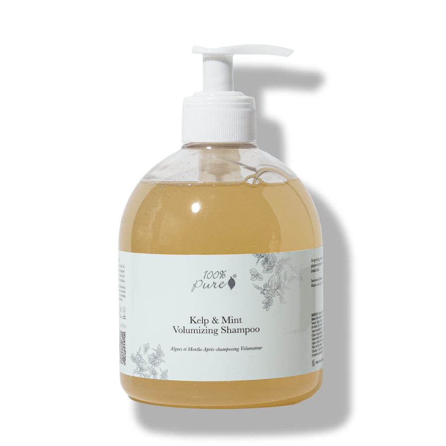 A bottle of 100% Pure Kelp & Mint Volumizing Shampoo with a white pump dispenser, containing a golden-amber liquid, set against a plain white background with a soft shadow.