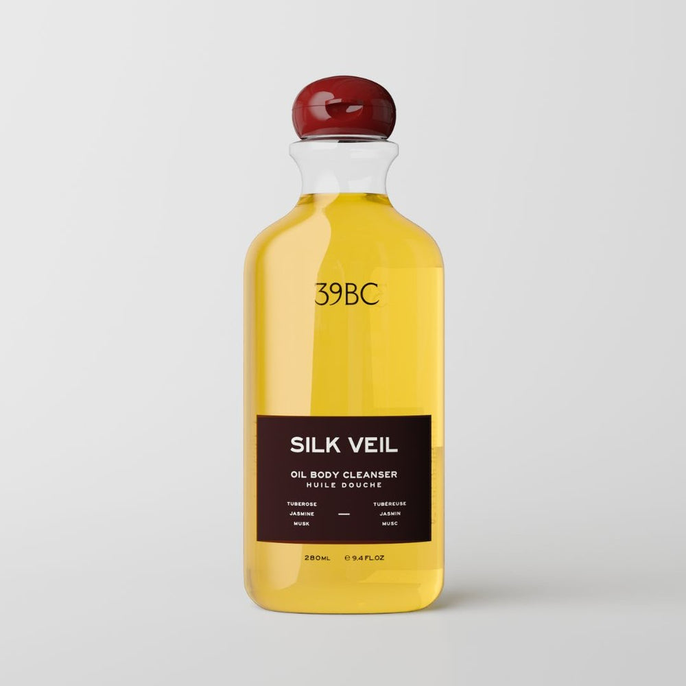 A 280ml bottle of 39BC Silk Veil Oil Body Cleanser, filled with a golden yellow liquid and featuring a dark brown label with a glossy red stopper, set against a plain white background.