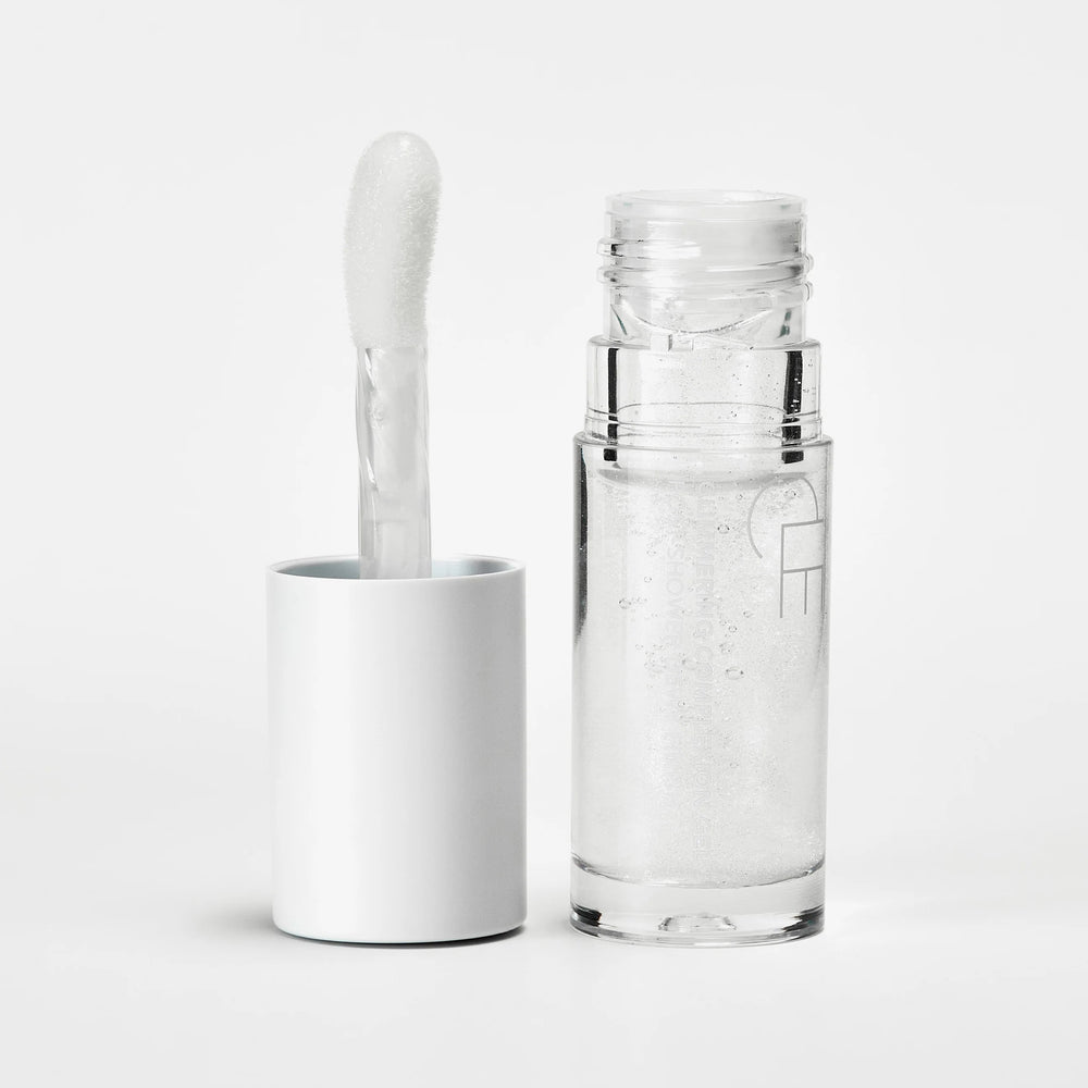 CLE Cosmetics Glimmering Complexion Gel with a clear jelly texture, subtle shimmer, and oil-based formula for a radiant, glass-skin finish. Features carrot seed oil and beta-carotene for a nourishing glow.