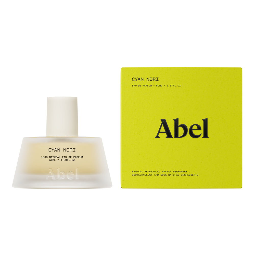 A frosted glass perfume bottle with a matte white cap, containing a pale yellow liquid. The label reads 'CYAN NORI 100% NATURAL EAU DE PARFUM' and features the brand name 'Abel' embossed near the bottom.