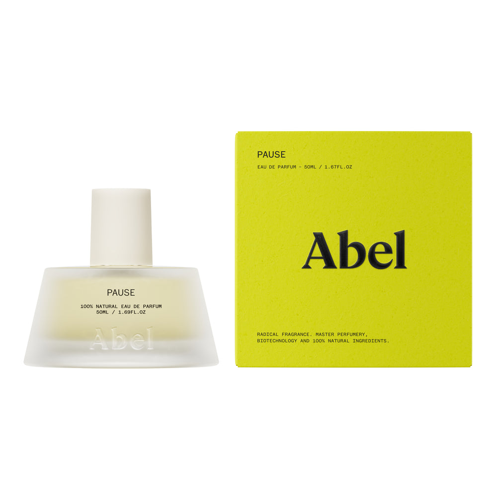 A frosted glass perfume bottle with a matte white cap, containing a pale yellow liquid. The bottle features the brand name 'Abel' and the fragrance name 'PAUSE' printed on the front, set against a solid white background.