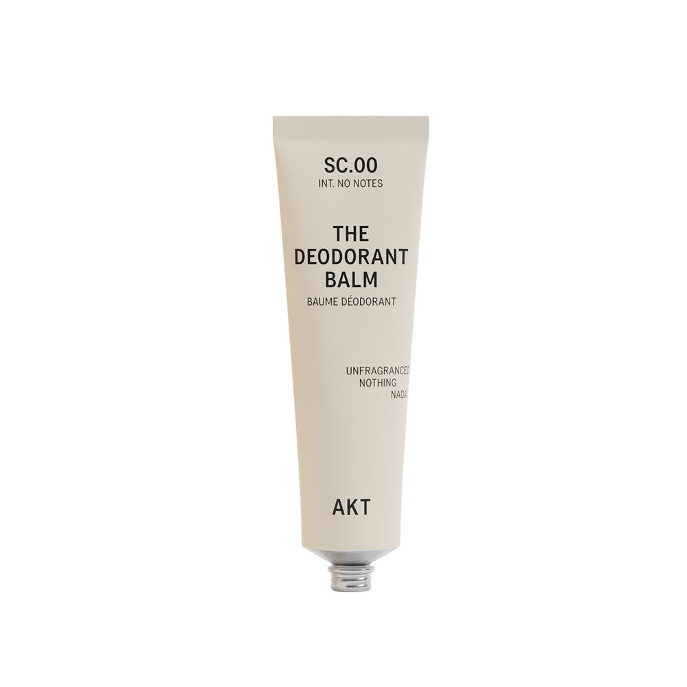 A single tube of deodorant balm by AKT London on a plain white background. The tube is a warm off-white/cream color with black text.