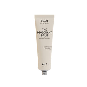 A single tube of deodorant balm by AKT London on a plain white background. The tube is a warm off-white/cream color with black text.
