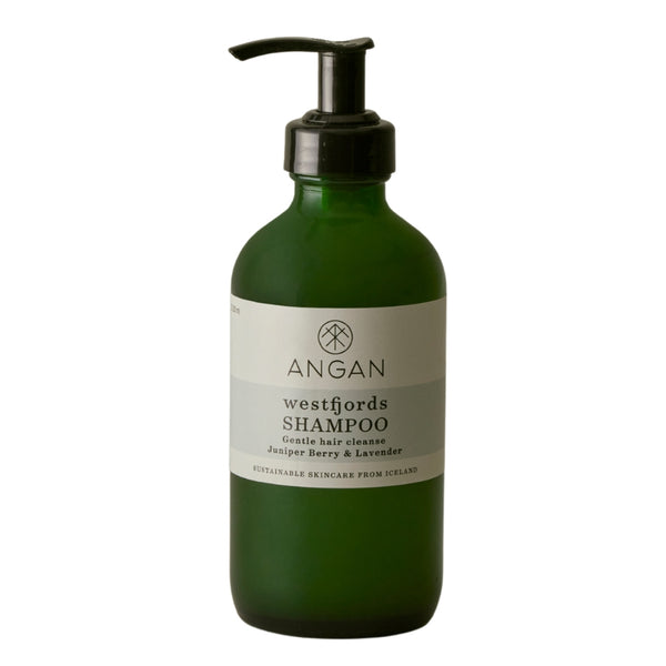 A dark green glass bottle of Angan Westfjords Shampoo with a black pump dispenser and a white label, set against a plain white background.