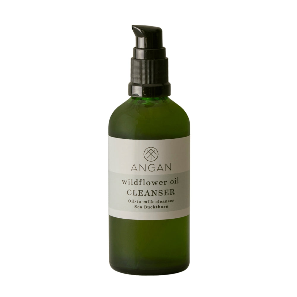 Angan Wildflower Oil Cleanser in a dark green glass spray bottle with a black pump dispenser and a white label, set against a plain white background.