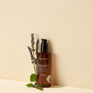 Brown bottle of Apoterra Vitamin C Body Oil with lavender sprigs on a beige background