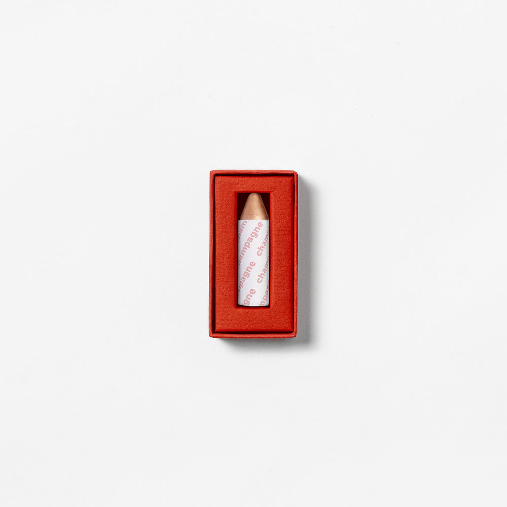 AXIOLOGY 3-in-1 Balmie Crayon Highlighter in Champagne, a plastic-free multi-use makeup crayon with a soft golden shimmer for eyes, lips, and cheeks.