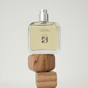 Rock Rose perfume bottle from Ayond with wooden blocks on a light gray background