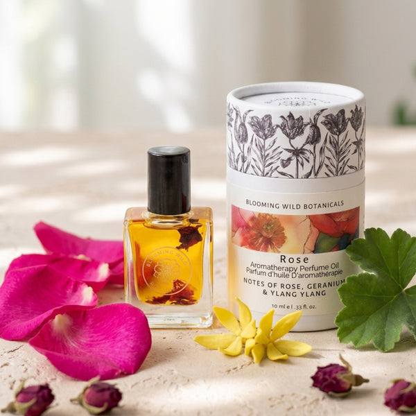 Perfume oil bottle and packaging with floral elements on a light surface