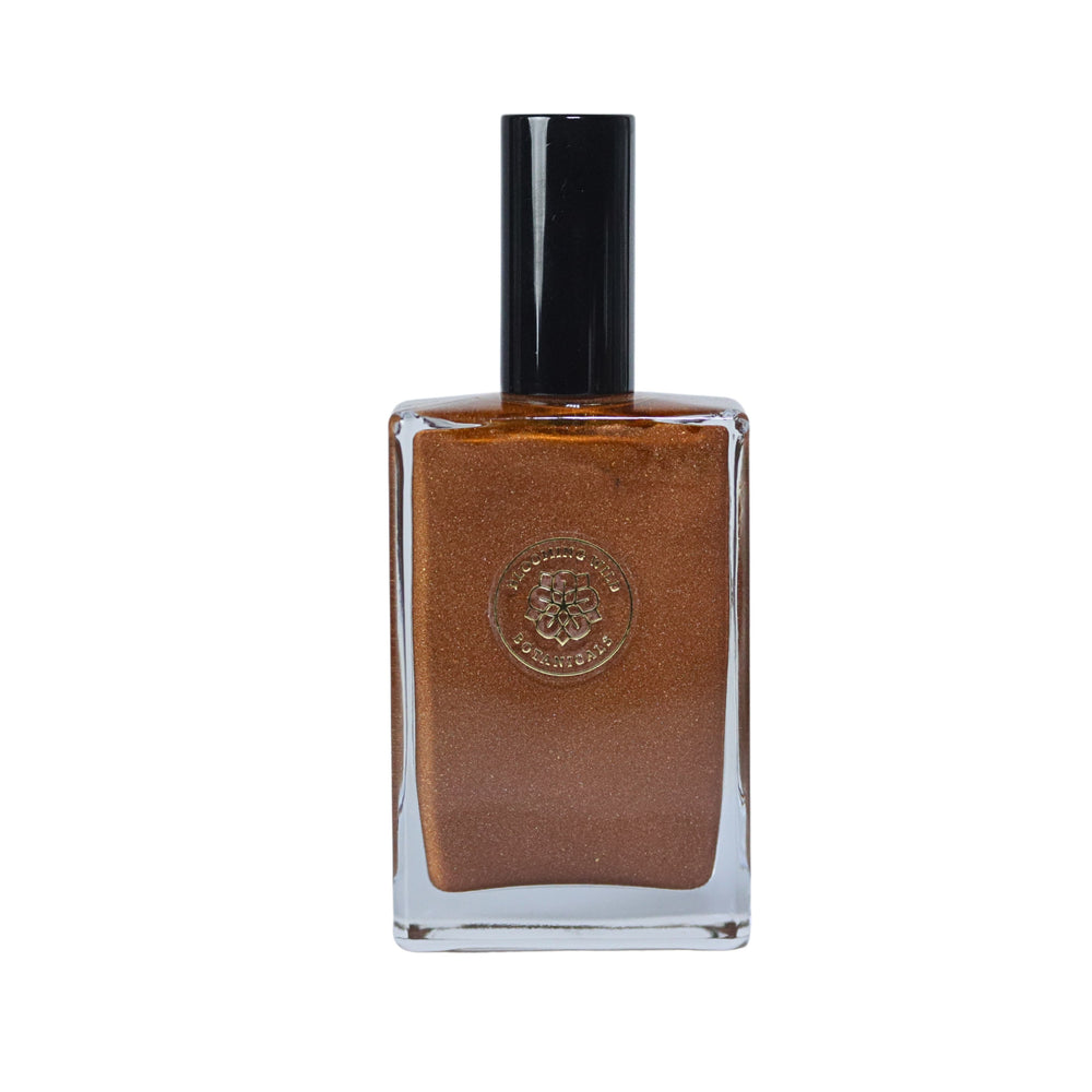 Blooming Wild Gardenia Glow Shimmering Body Oil in a glass bottle, golden-bronze tint with gardenia and coconut infusion for radiant, luminous skin.