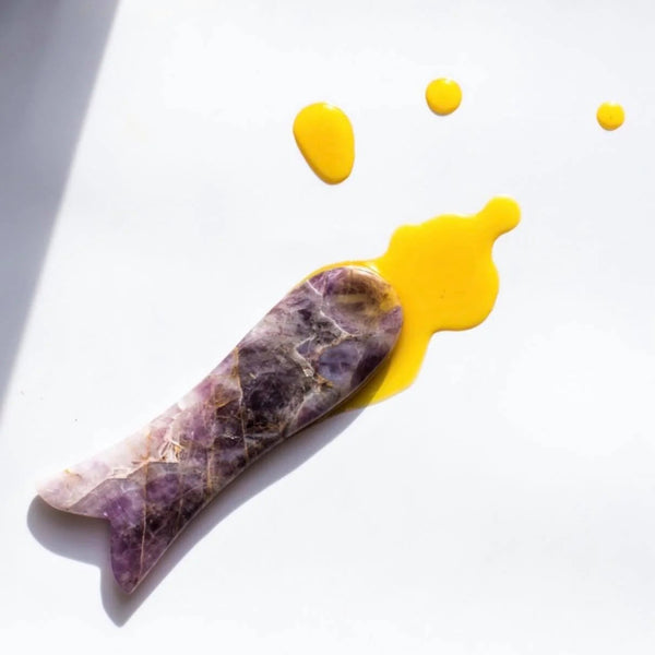 By Achilles Amethyst Gua Sha, a natural, handcrafted tool for facial contouring and calming skincare routines.