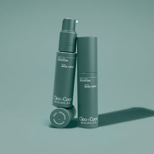 Two green bottles of 'Cleo + Coco' powder on a gray background