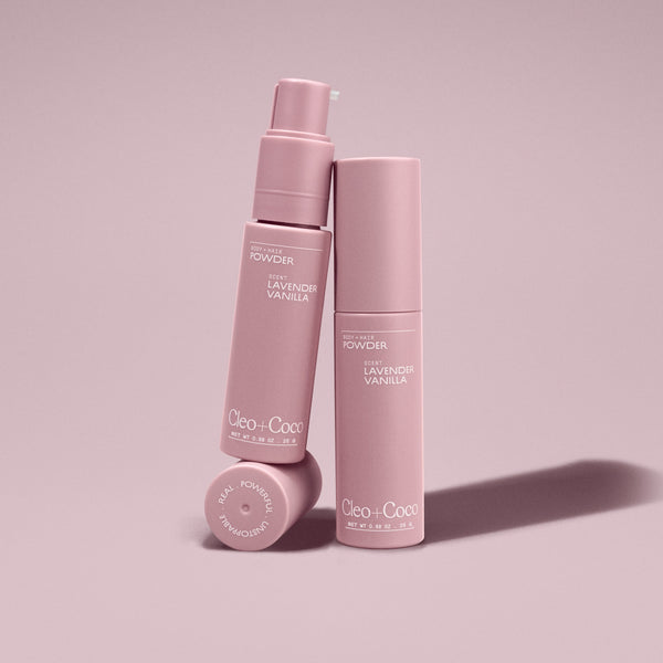 Two pink bottles of 'Cleo & Coco' powder on a light pink background