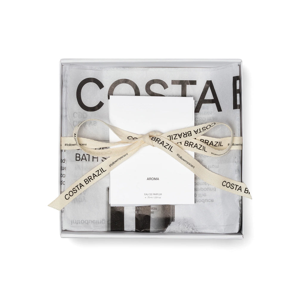 Two bottles of Costa Brazil shampoo and conditioner with a wooden comb on a white background