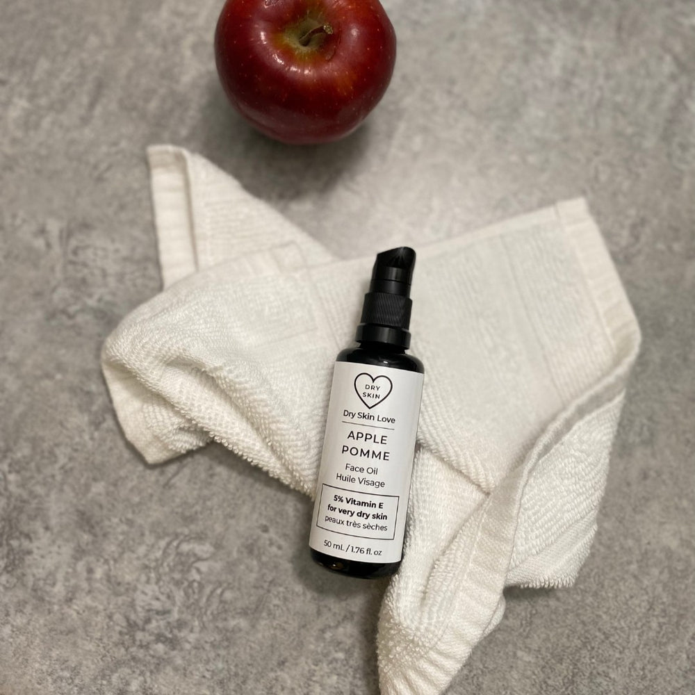 Dry Skin Love Apple Elixir 5% Vitamin E Face Oil in black glass 50ml bottle with white label and black pump for dry skin with blend of vitamin E forms, apple seed oil, coconut oil, and chamomile extract.