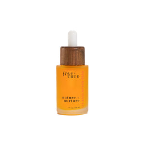 FREE + TRUE Nature + Nurture face oil in clear glass bottle with white and bamboo pipette on white background