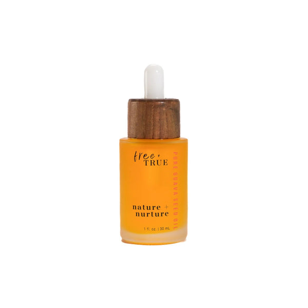 FREE + TRUE Nature + Nurture face oil in clear glass bottle with white and bamboo pipette on white background