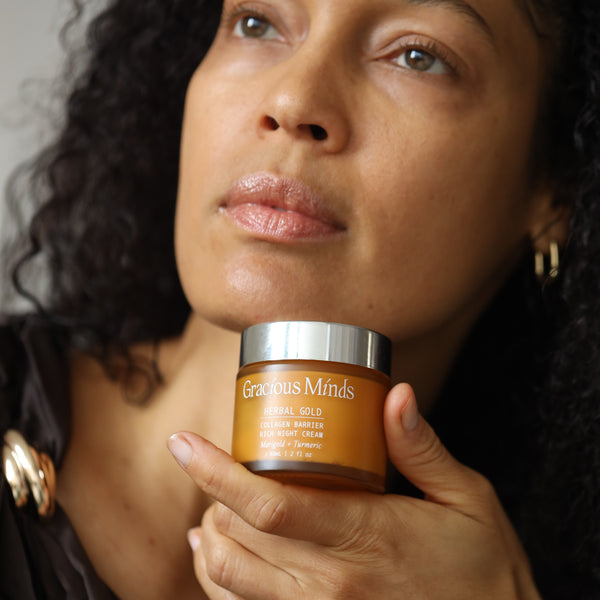 Woman holding a glass jar of 'Gracious Minds' product close to her face