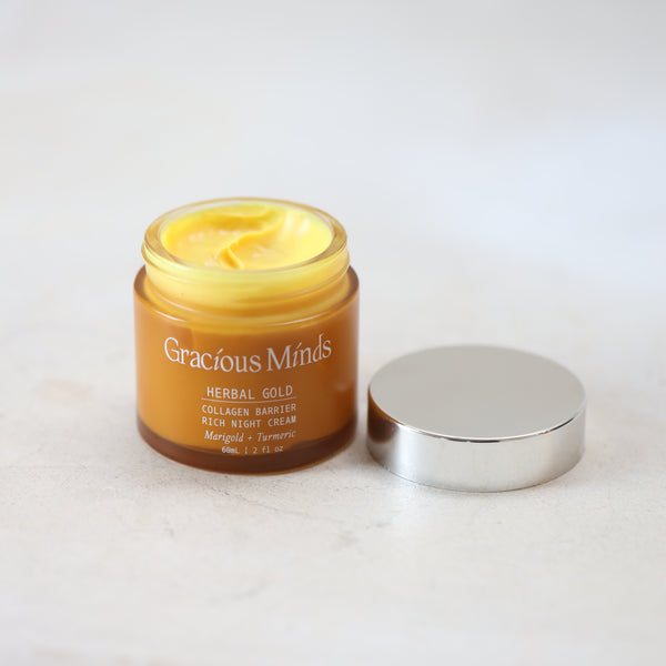 glass jar of Gracious Minds Herbal Gold cream on a white background