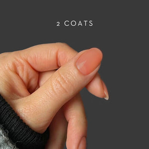 Hand with a single painted nail on a dark background with '2 COATS' text. HELLO TOMATO Djamor