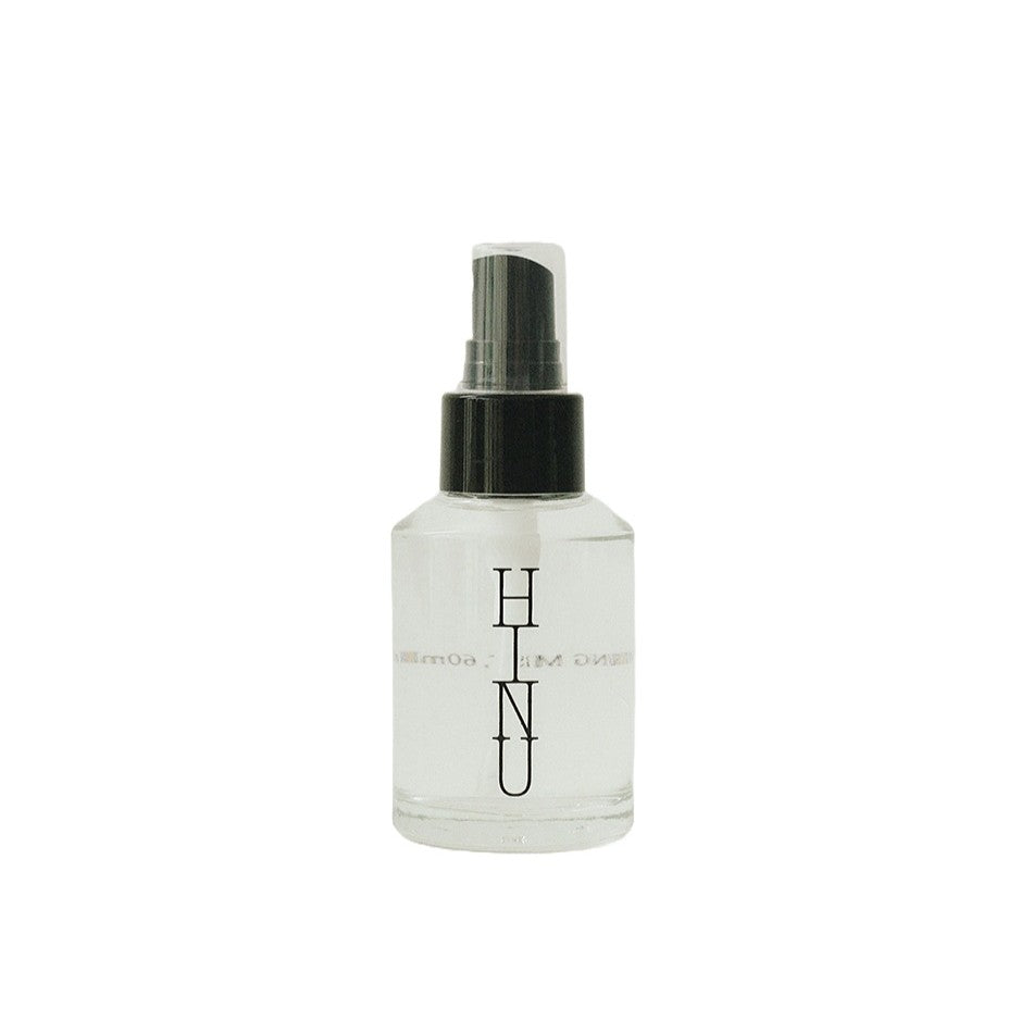 Glass bottle of HINU Hydrating Mist with a minimalist label — a lightweight floral mist designed to hydrate, balance the scalp, and soften hair and skin.