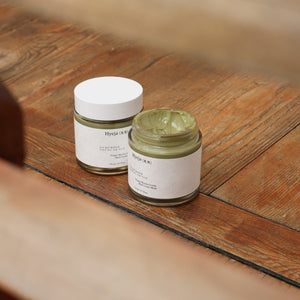 Two jars of Hyeja Vegan Matcha Gentle Mud Cream Mask on a wooden surface
