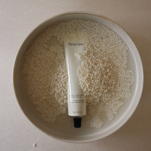 Tube of Hyeja cream in a bowl filled with rice on a beige background