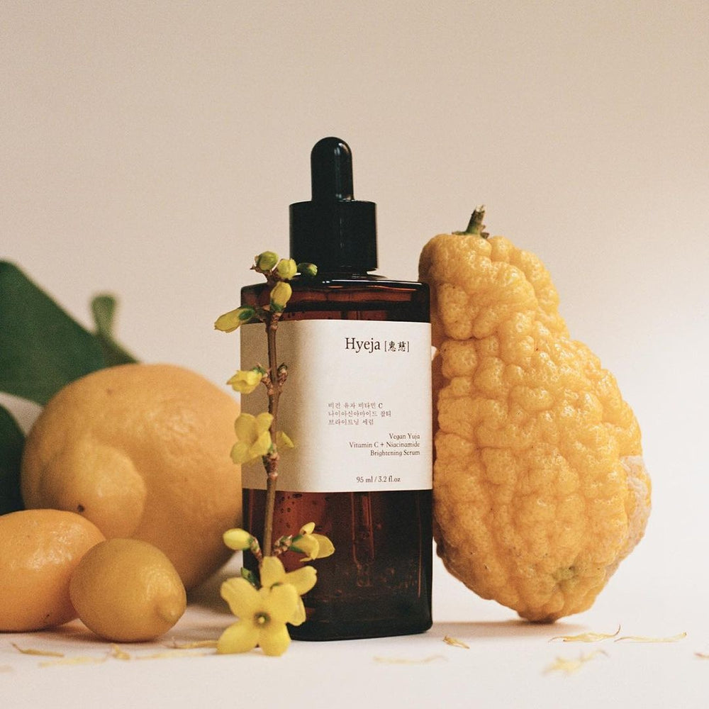 HYEJA Yuja Vitamin C Brightening Serum in amber glass bottle with black pipette on white background.