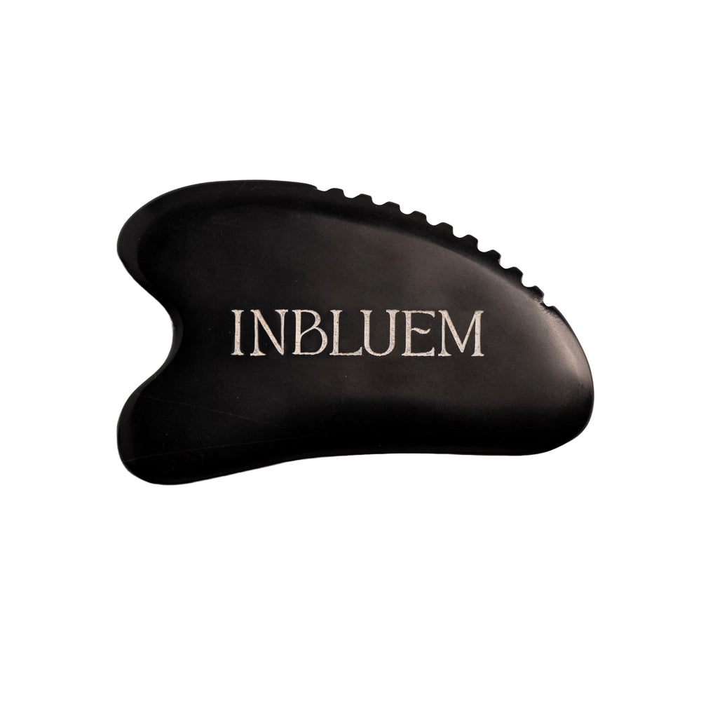 Black gua sha tool with 'INBLUEM' branding on a white background