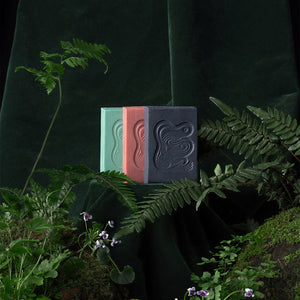 Three soap bars in green, red, and light black color on a dark background with foliage. INBLUEM Soul Soap Finger Lime & Eucalyptus