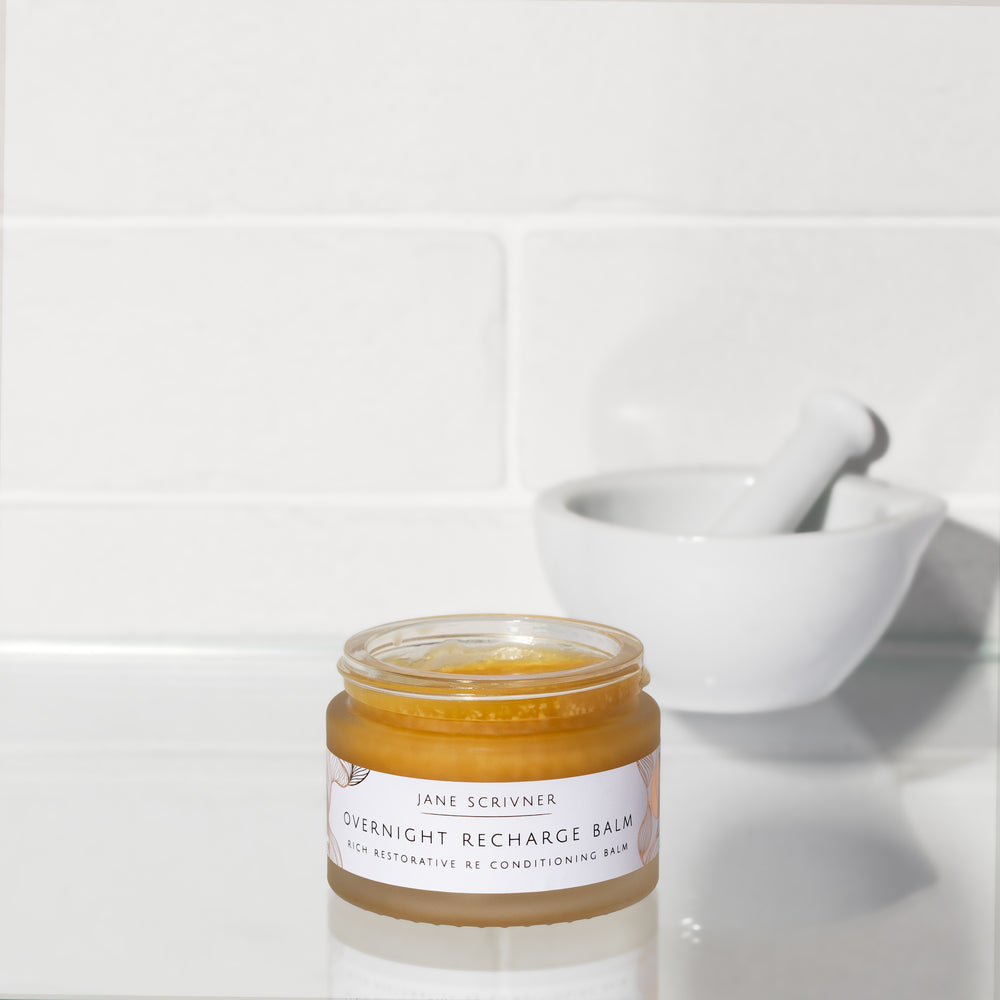 Jane Scrivner Overnight Recharge Balm in a clear jar showing the beige balm inside, with a white lid and label, set against a white background with a soft shadow.