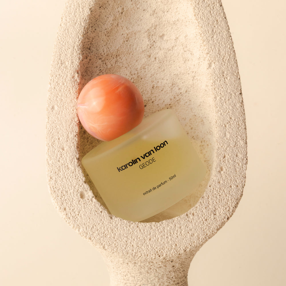 Perfume bottle with a marbled cap on a white background