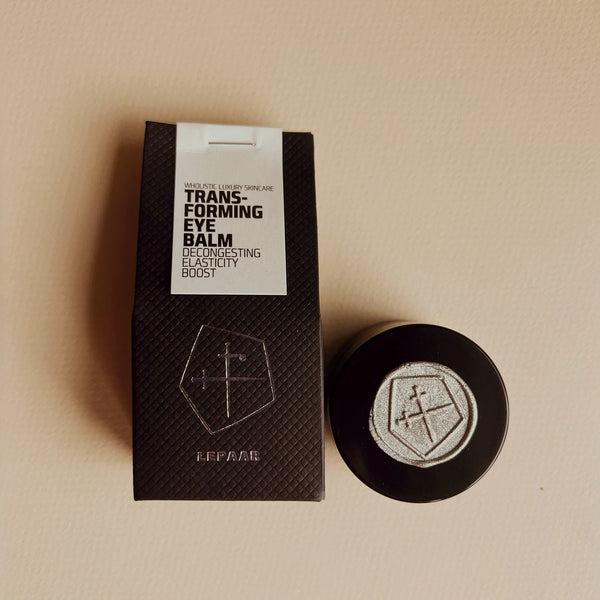 Transforming eye balm packaging with a black box and white label on a beige background. LEPAAR Transforming Eye Balm / Zero Essential Oil