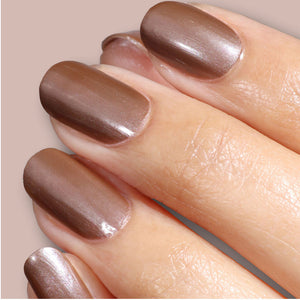 Close-up of a hand with shimmering brown nail polish on a neutral background
