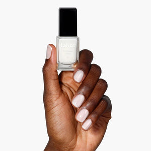 Hand holding a bottle of LONDONTOWN Double Scoop nail polish with a white background