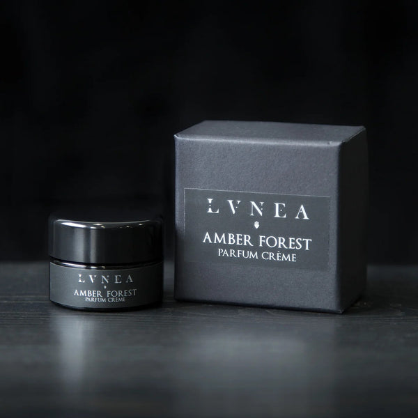 LVNEA Amber Forest Parfum Crème in an amethyst glass pot—warm amber fragrance with poplar bud, spruce resin, and labdanum.