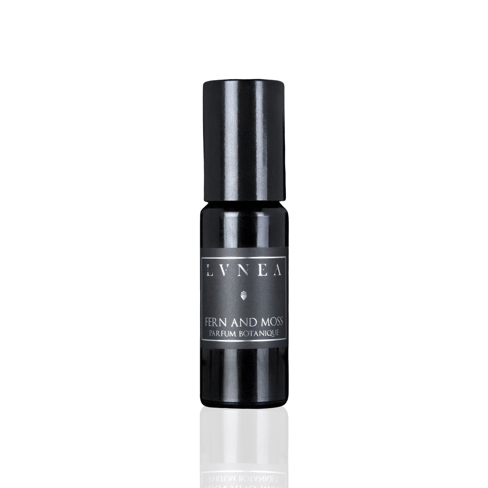LVNEA Fern And Moss Parfum Botanique in an amethyst glass bottle with a roller ball, featuring notes of fresh herbs, lavender, tonka bean, and green moss. A soft, aromatic fragrance with green and coumarin aspects.