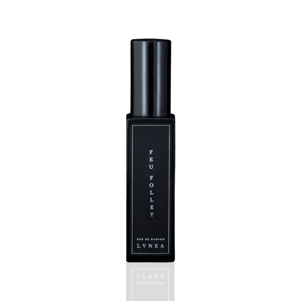 LVNEA Feu Follet Eau De Parfum - a black glass bottle containing a smoky, resinous fragrance with notes of pine tar, burnt wood, leather, and tree resin. Presented with an atomizer spray top. 30ml