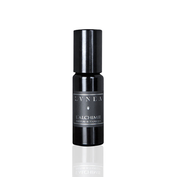 LVNEA L'alchimie Parfum Botanique in a 10ml black amethyst glass bottle with a glass roller ball, encased in a matte black tube. The fragrance features notes of blood orange, amber, and rose, creating a rich, warm, and floral scent profile.