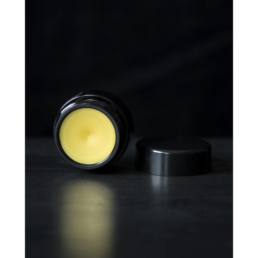 LVNEA Midnight Tuberose Parfum Crème in a 10g amethyst glass pot, nestled in a gift box. The solid perfume features notes of tuberose, rose, sandalwood, and a touch of cocoa, offering an enveloping, narcotic floral scent with resinous and wood undertones.