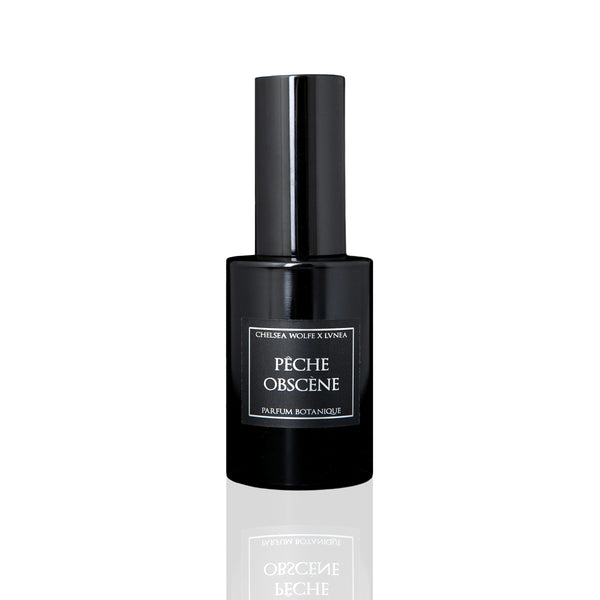 Amethyst glass bottle of LVNEA Pêche Obscène Eau de Parfum, featuring notes of peach, jasmine, and patchouli, encased in a matte black tube.