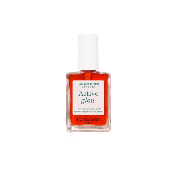 Bottle of MANUCURIST Active Glow™ Cranberry coral nail polish with a glossy, translucent finish.