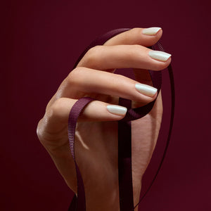 Hand holding a black ribbon against a dark red background