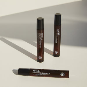 Three bottles of MAULI Grow Strong Brow Oil on a light background