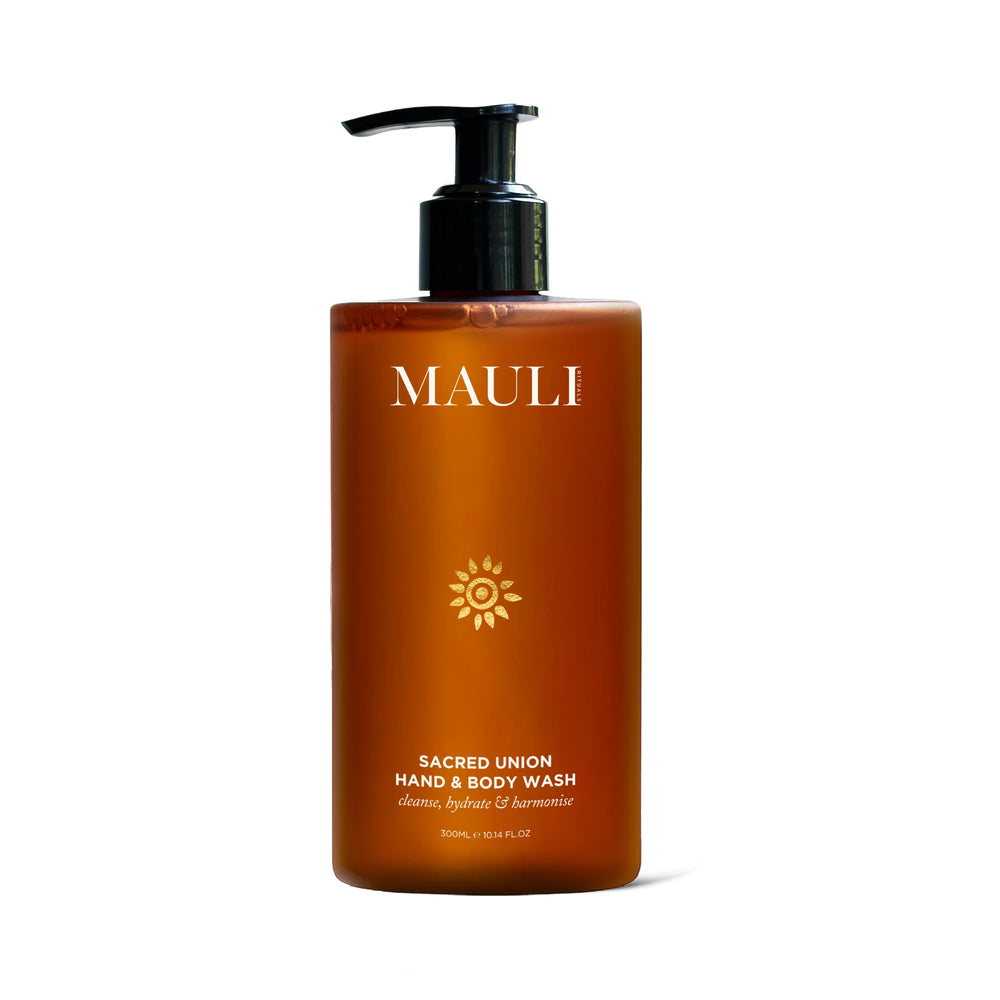 A dark orange bottle of MAULI RITUALS Sacred Union Hand & Body Wash with black pump on white background