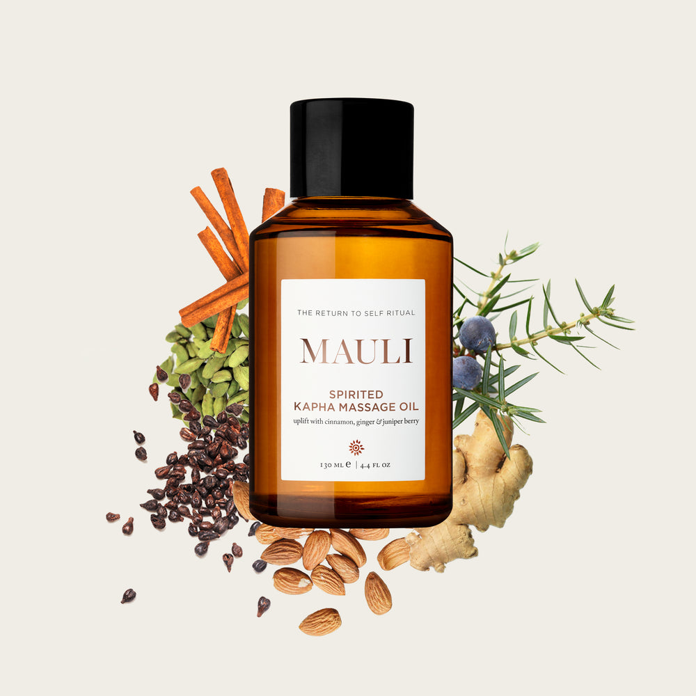 An amber glass bottle of MAULI RITUALS Spirited Kapha Body Oil on white background