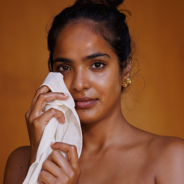 Woman holding a white muslin cloth with an orange background