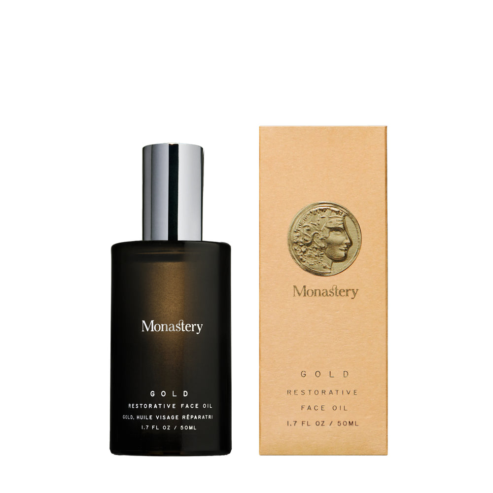 MONASTERY MADE GOLD Botanical Oil Serum in glass bottle with silver cap next to its box packaging, on white background